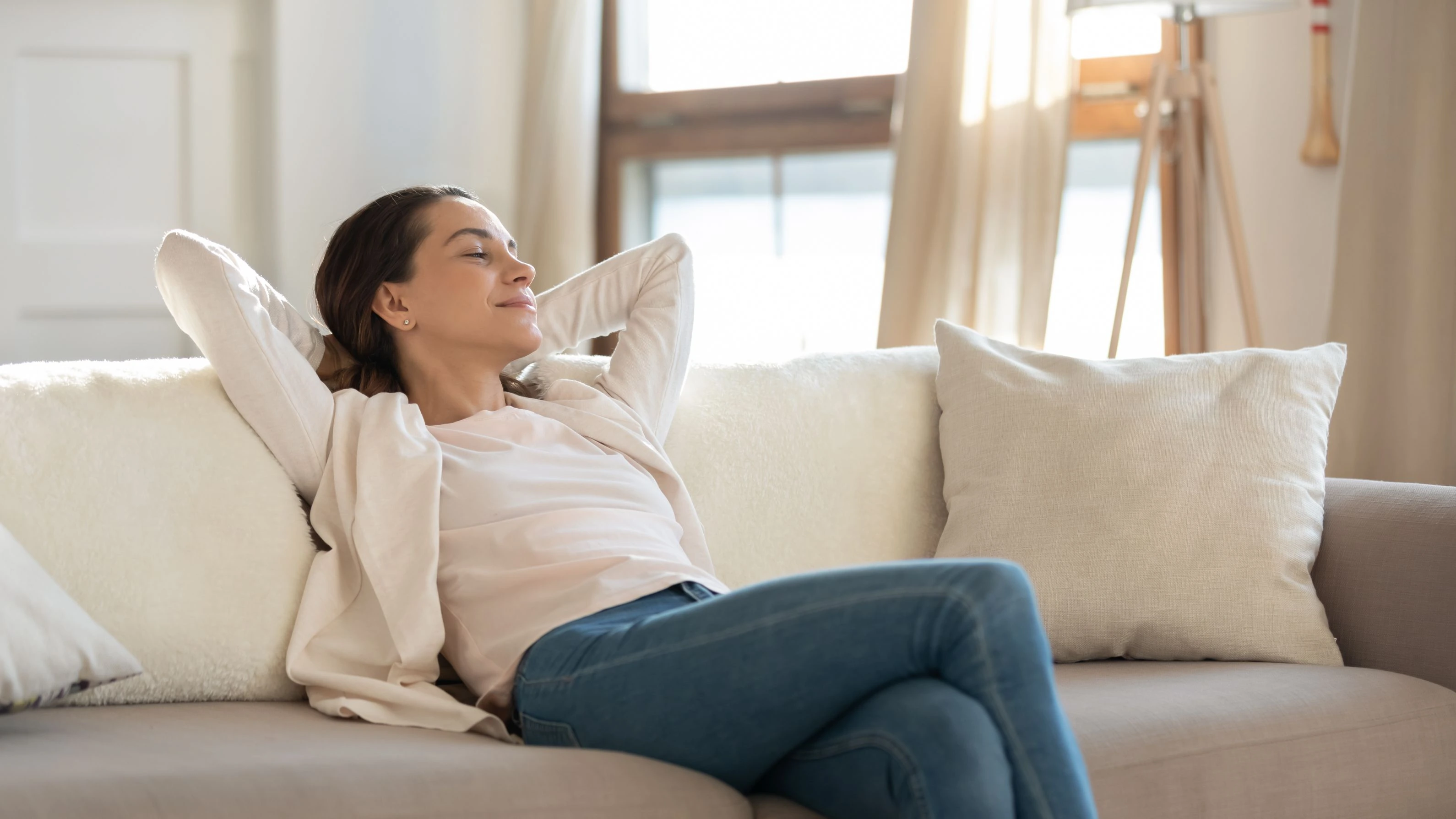 Woman relaxing on a sofa in an air-conditioned living room