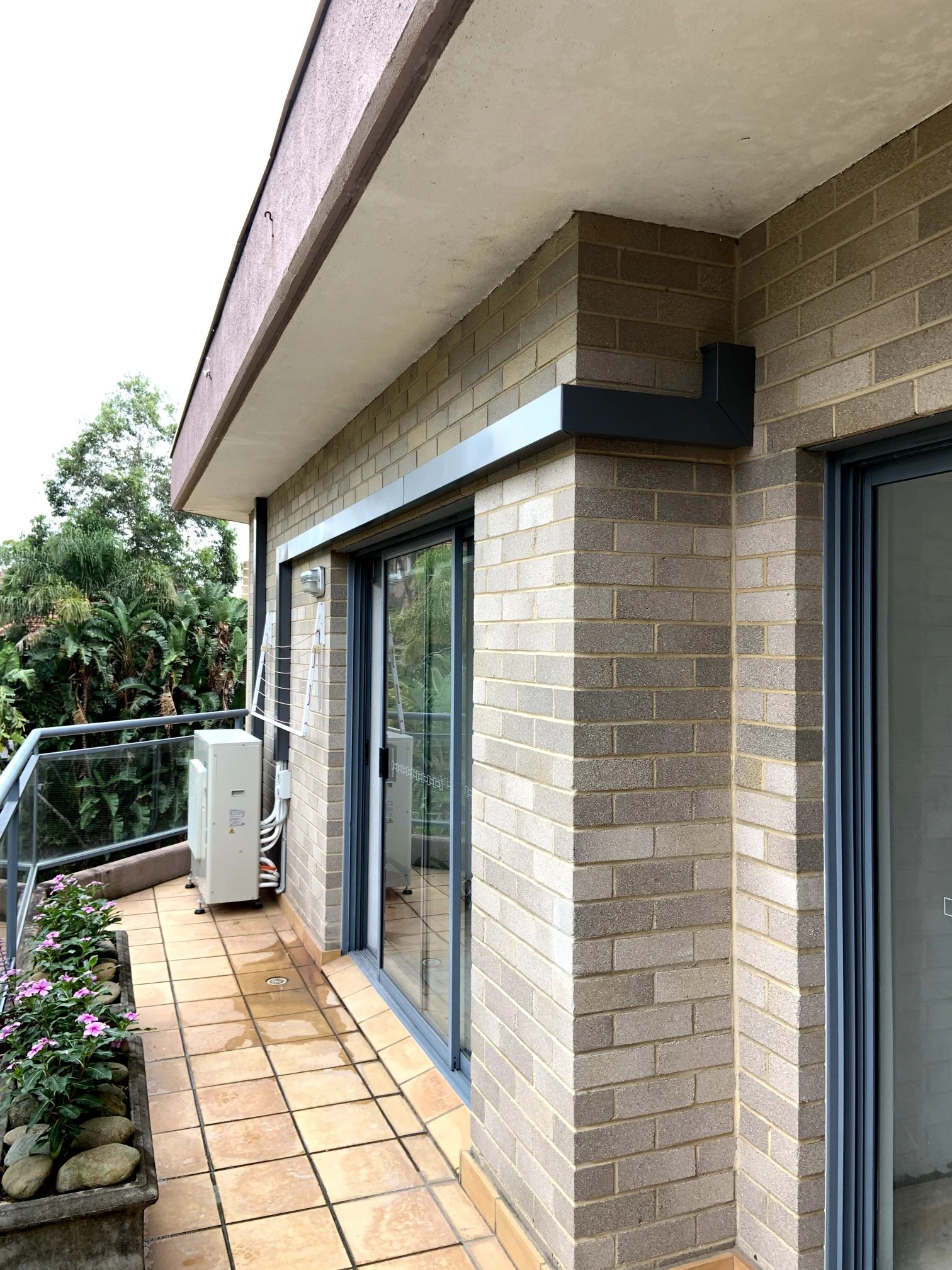 Residential outdoor air conditioning installation beside a balcony